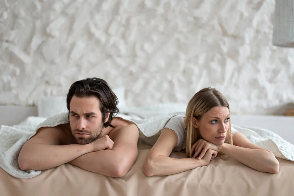 Paar liegt abgewandt im Bett